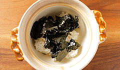 おにぎりは、ごはんとのりに分ける。鍋にご飯を入れ、糊をちぎって加える。